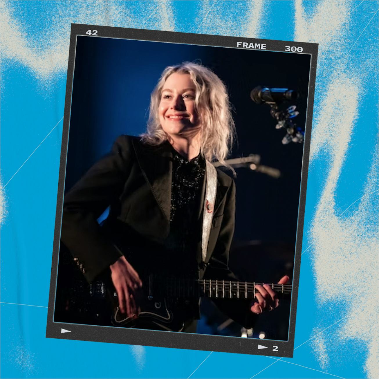 Phoebe Bridgers, a songwriter, and guitarist, wearing a black shirt and suit, holding a guitar in fr...