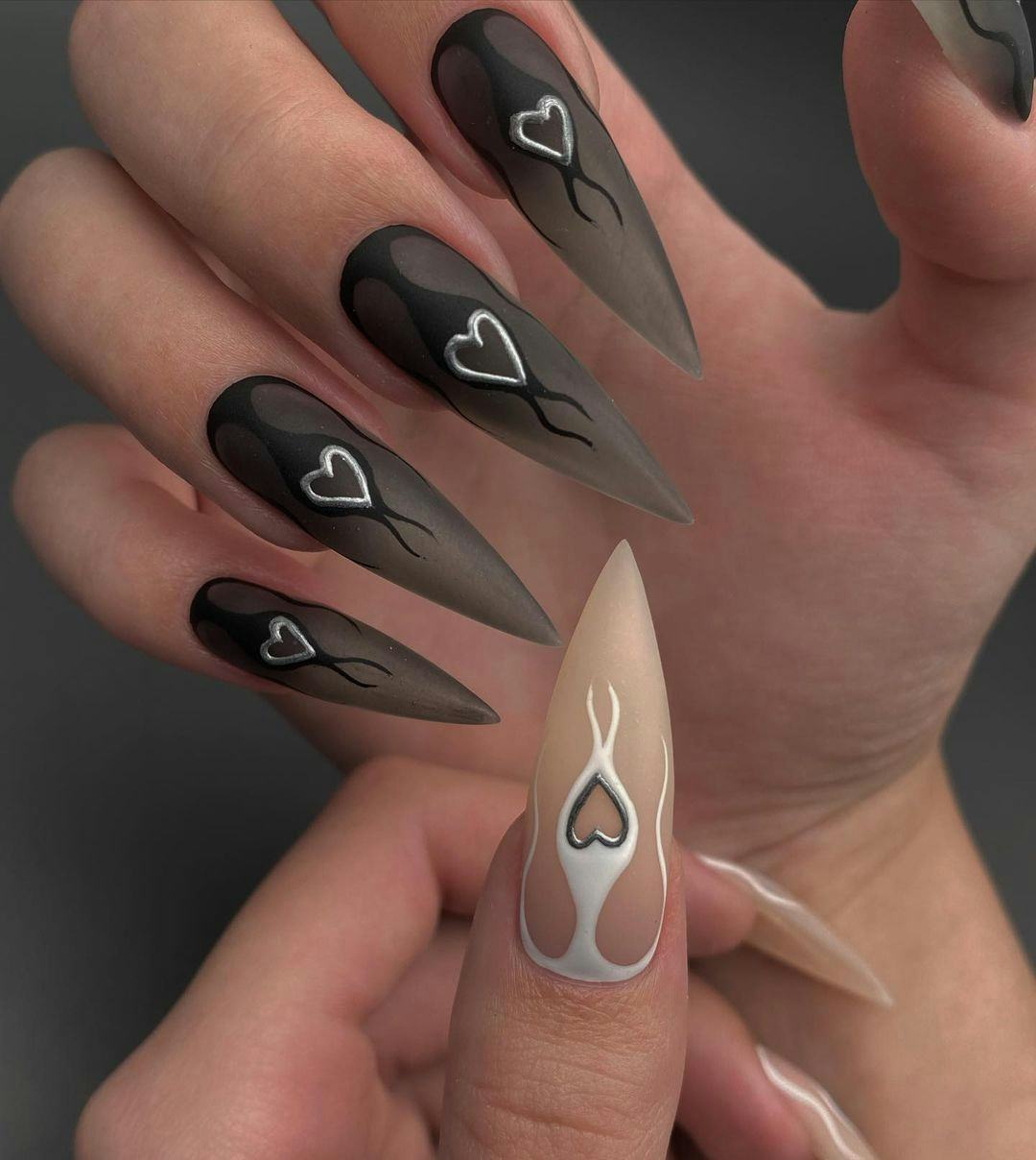 Long black nails with silver hearts inspired by the horoscope sign of Scorpio.