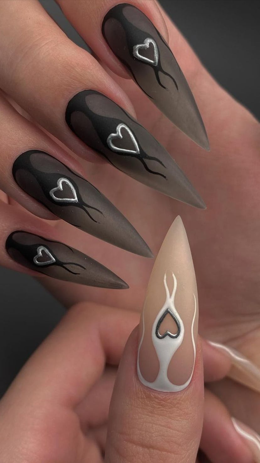 Long black nails with silver hearts inspired by the horoscope sign of Scorpio.
