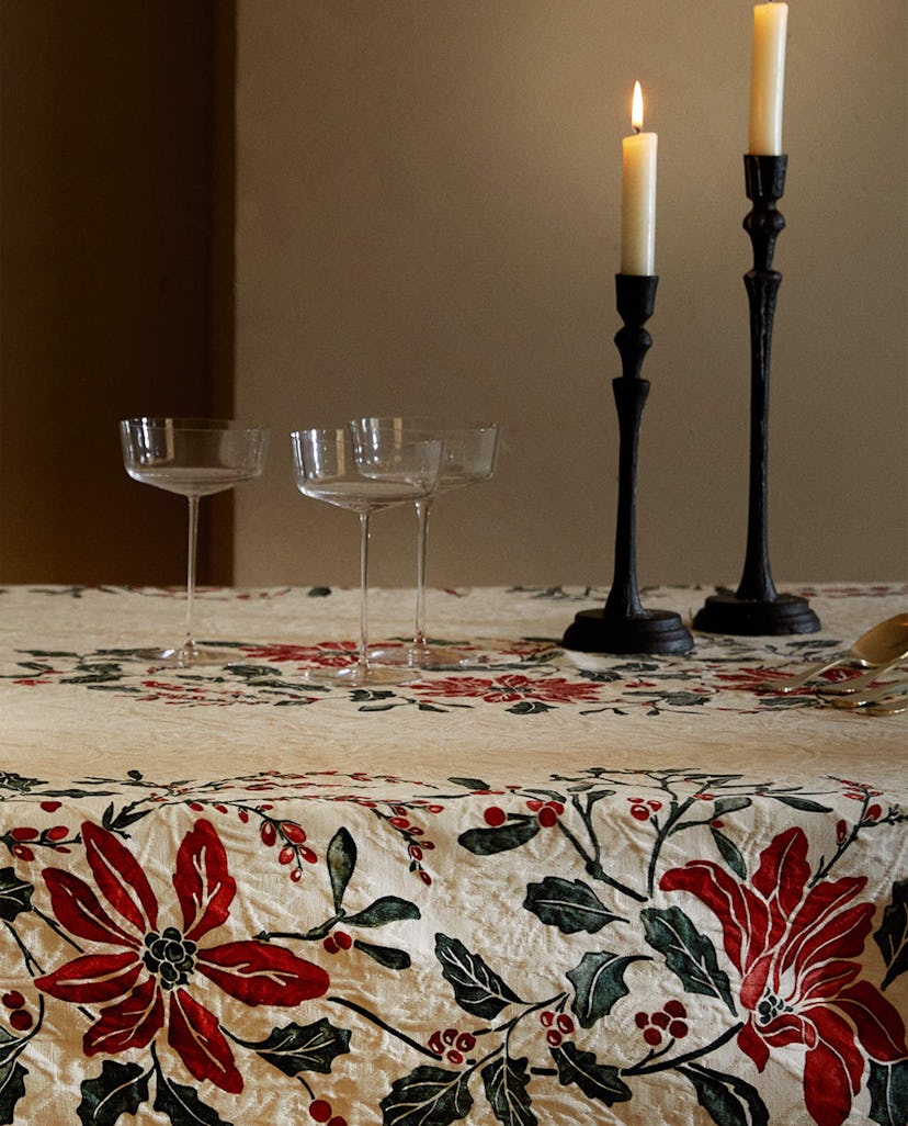 A dining table is decorated with wine glasses and candle holders from Zara Home’s Holiday Collection