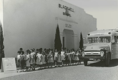 Children at Blackwell School lined up next to school bus