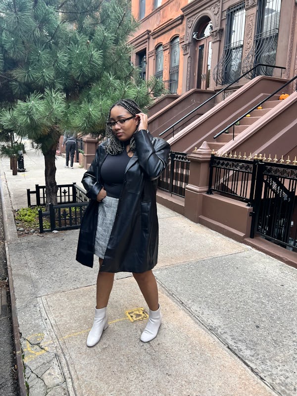 A mid-size woman wearing a black leather coat and a black mini skirt by Abercrombie