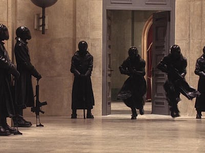 Six members of underground resistance forces wearing full-black uniforms and guns