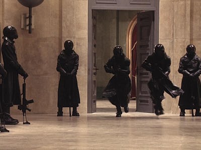 Six members of underground resistance forces wearing full-black uniforms and guns