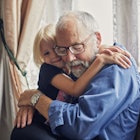 A grandfather hugging his granddaughter.