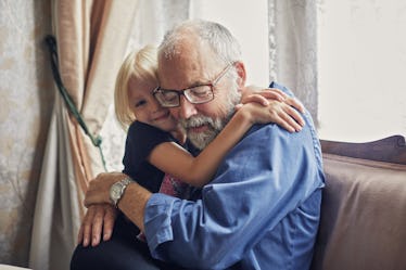 A grandfather hugging his granddaughter.