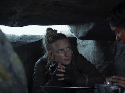 Commander D’Acy listening to an unknown person in the shelter made from rocks