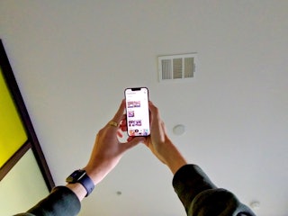 A photo of two hands holding a phone taken with the Ray-Ban Stories.