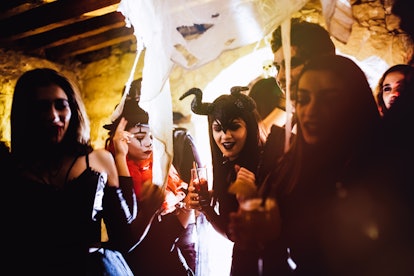 Friends partying in costume after reading their Halloween 2022 horoscope.