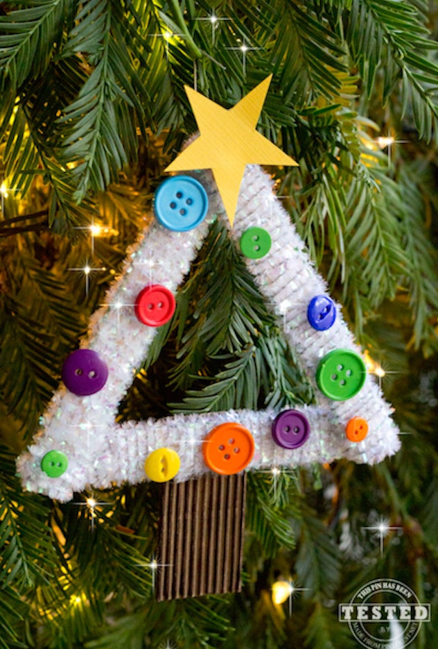 A DIY kids Christmas tree ornament is a festive decoration made with buttons and popsicle sticks.
