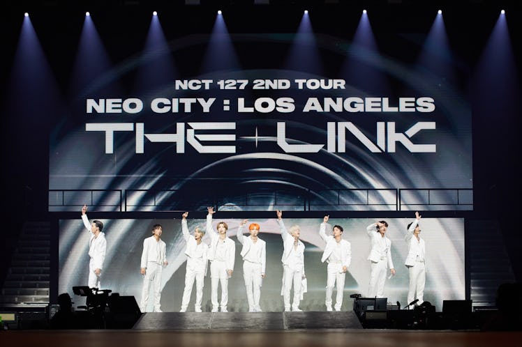 Band NCT 127 performing at their 'Neo City: The Link' show in Newark wearing all white.