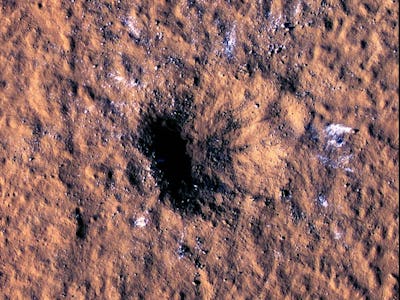 The brown-colored surface of Mars with a deep crater that was caused by a Meteor strike