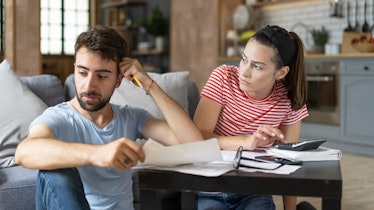 A husband looks frustrated while doing finances with his wife.