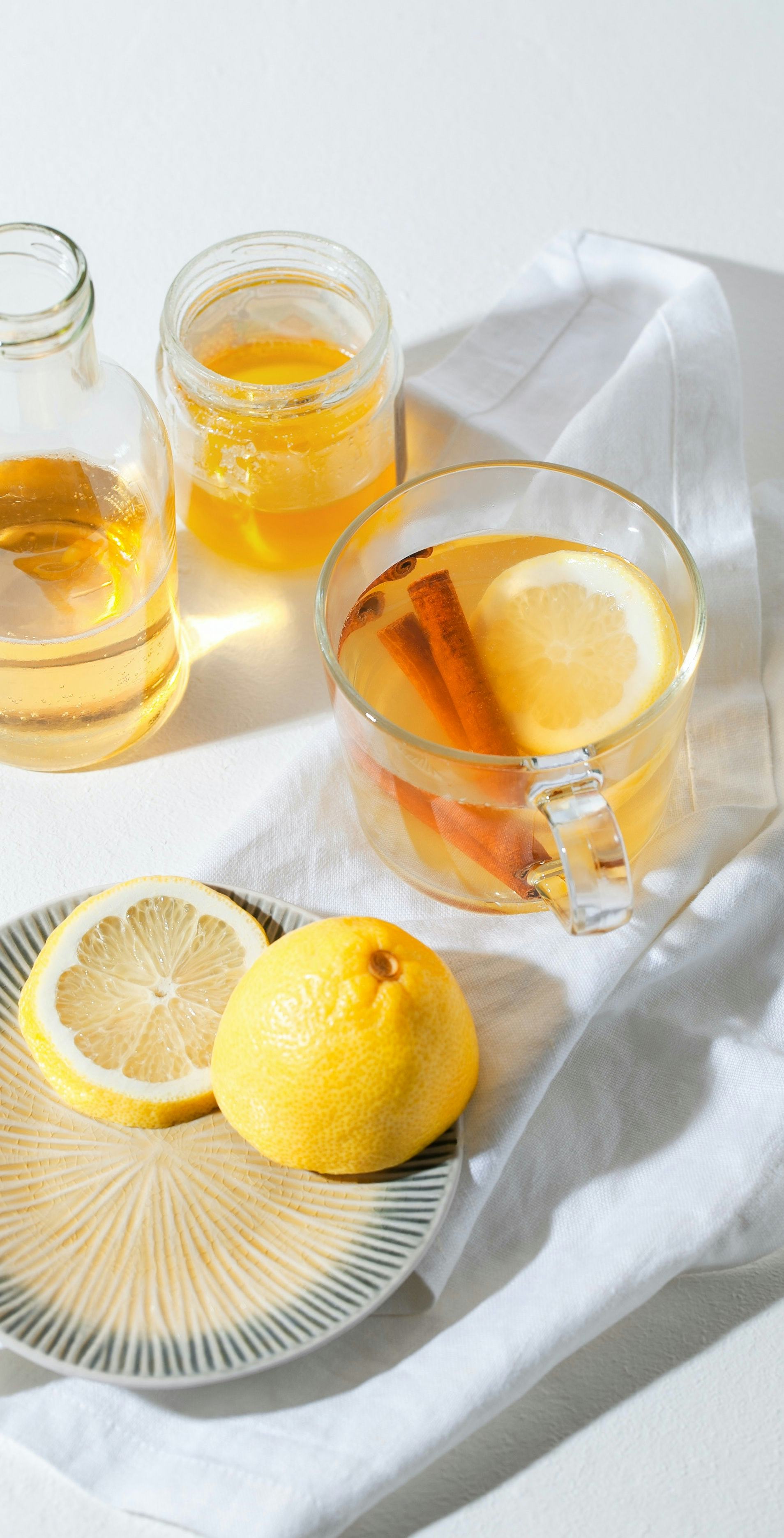 Cup of Hot Toddy Cocktail garnished with lemon slice and cinnamon sticks