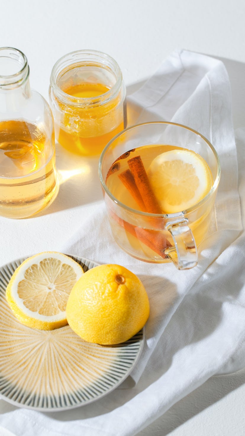 Cup of Hot Toddy Cocktail garnished with lemon slice and cinnamon sticks