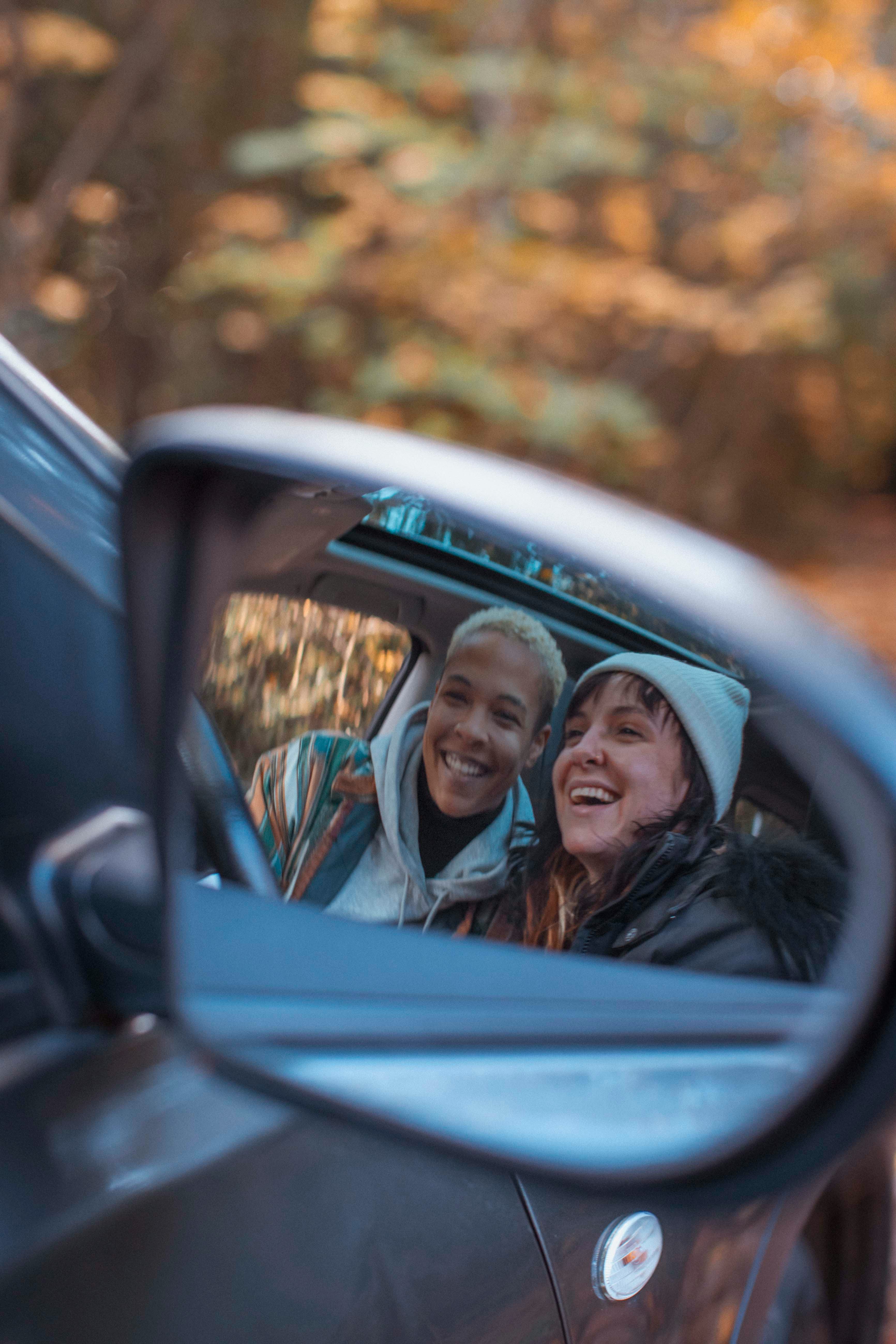 Young couple taking a selfie in a car mirror on the most romantic day in November 2022.