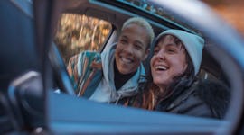 Young couple taking a selfie in a car mirror on the most romantic day in November 2022.