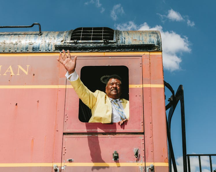 Sammy Stephens waving in the yellow suit from the red train’s window