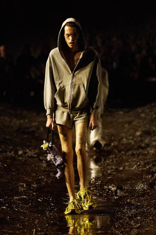 A model walking the mud Balenciaga show in a grey hoodie