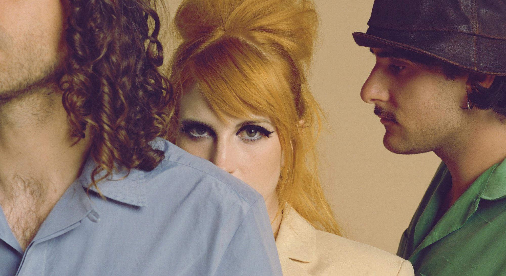 Ginger woman with black eyeliner between two men for the cover of NYLON's soundcheck.