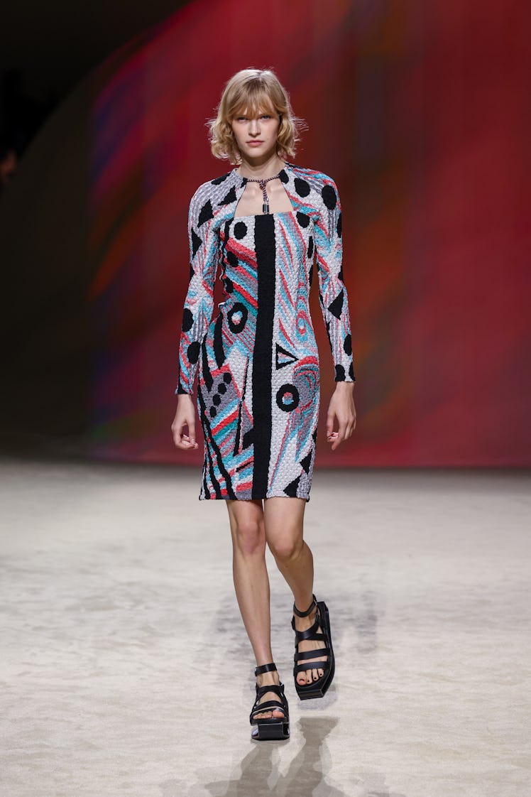 A model in Hermès knee-high dress in black, gray, red, and turquoise print color at Paris Fashion We...