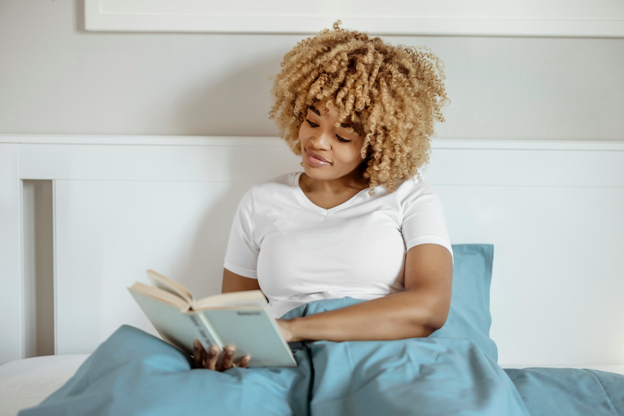 Woman reading a book in bed.