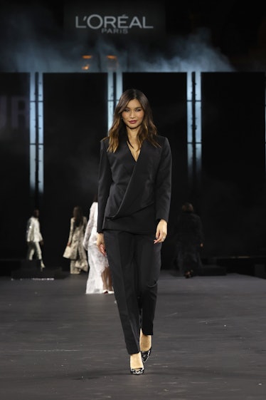 Gemma Chan wearing a black suit on the L'Oréal spring 2023 runway