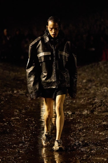 A male model walking the mud Balenciaga show in a black leather jacket