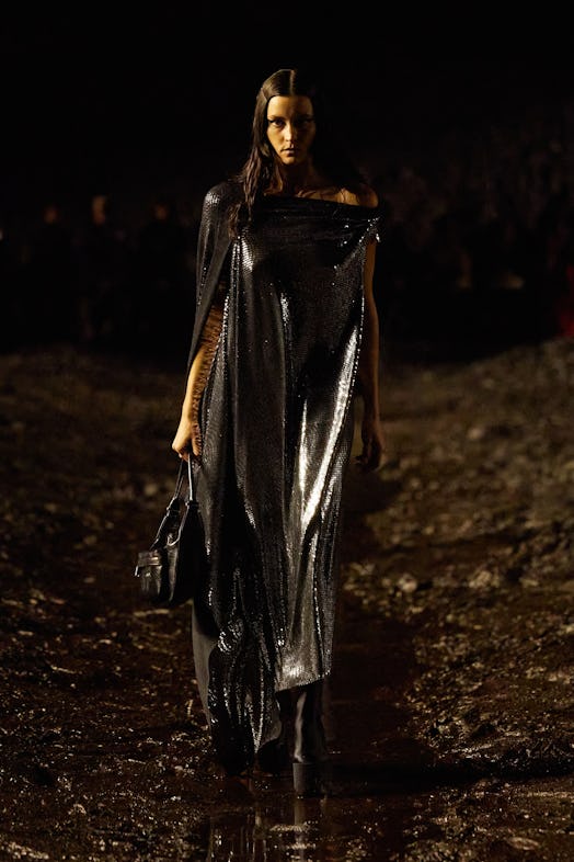A female model walking the mud Balenciaga show in a black sequin gown