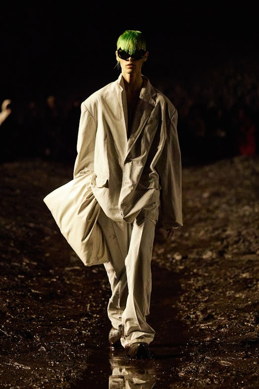 A model walking the mud Balenciaga show in an oversized blazer and pants combination