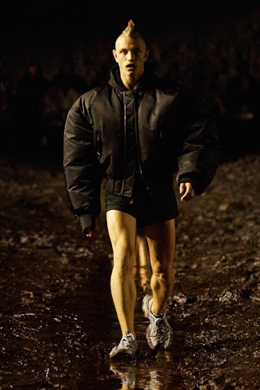 A male model walking the mud Balenciaga show in a black jacket