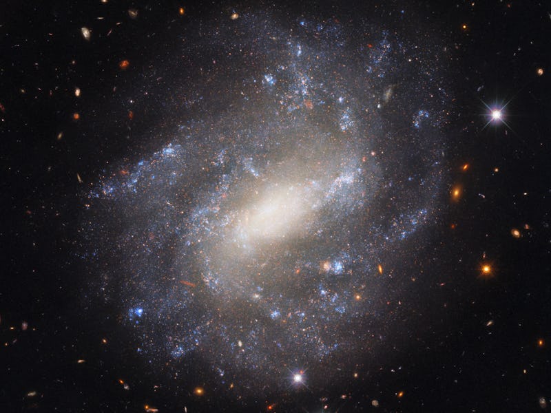 Image of a spiral galaxy in space, with smaller galaxies in the background