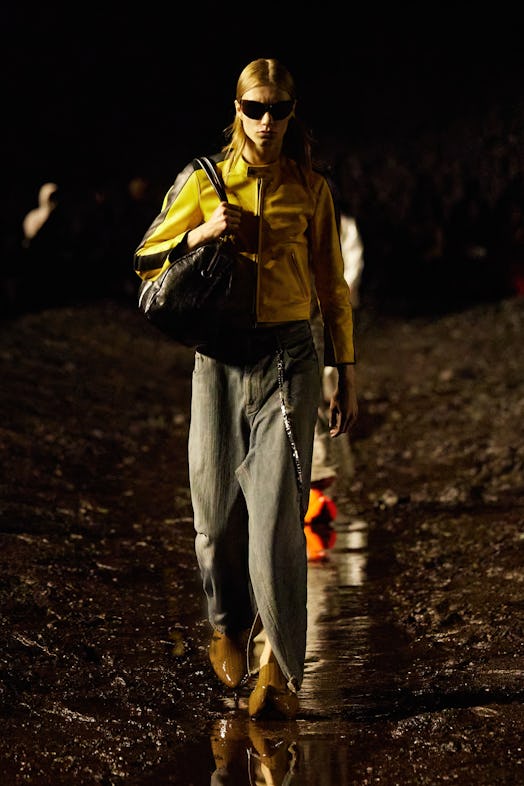 A male model walking the mud Balenciaga show in a yellow jacket