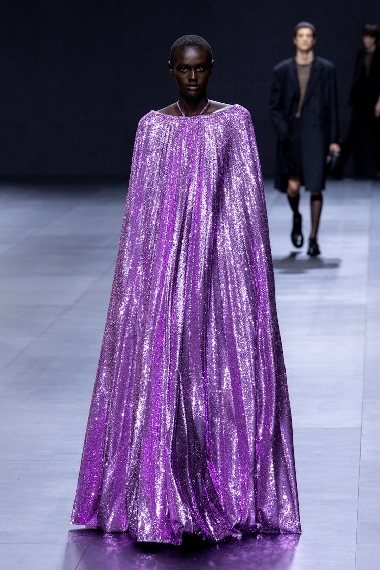 A model in Valentino sequined cape maxi dress in bright purple color at Paris Fashion Week Spring 20...
