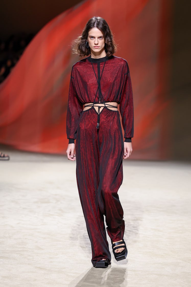 A model in Hermès black and red maxi jumpsuit with the stomach cutout detail at Paris Fashion Week S...