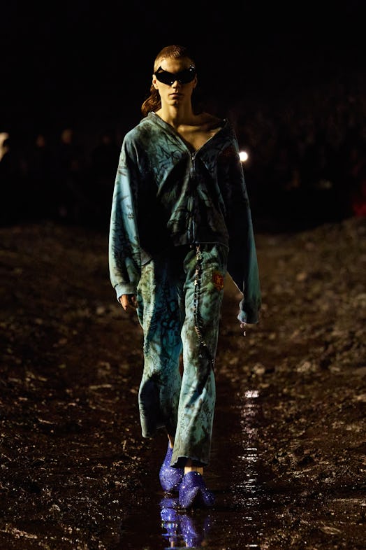 A model walking the mud Balenciaga show in a green shirt and pants