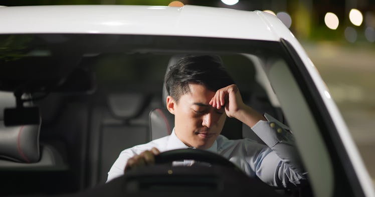 A man looking said while driving a car.