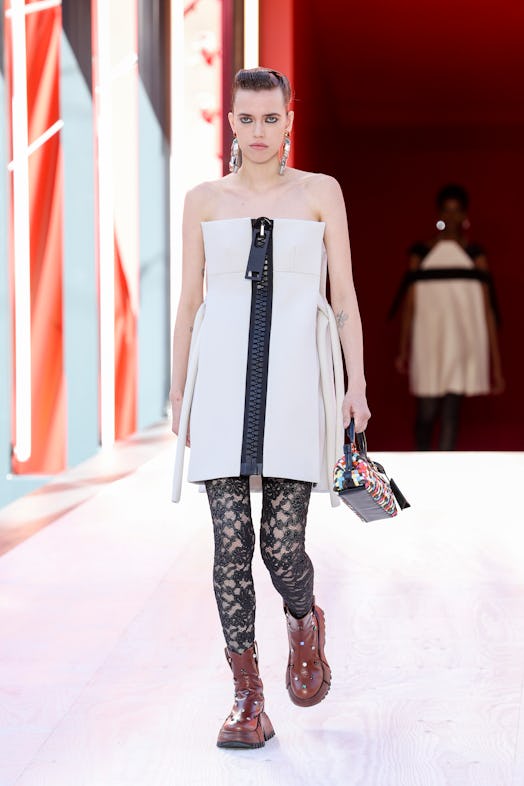 A model in a white off-the-shoulder dress with a giant zipper at the Louis Vuitton Spring 2023 Paris...