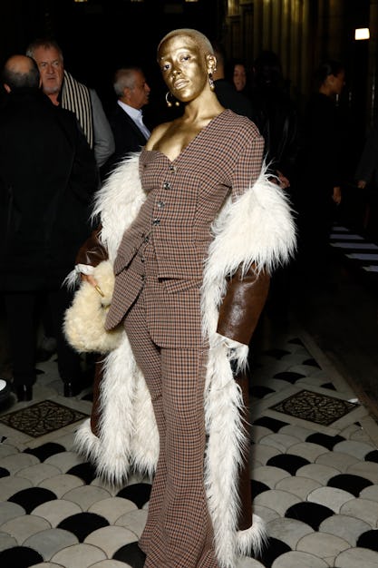 A gold-covered Doja Cat wearing a plaid suit and fuzzy coat