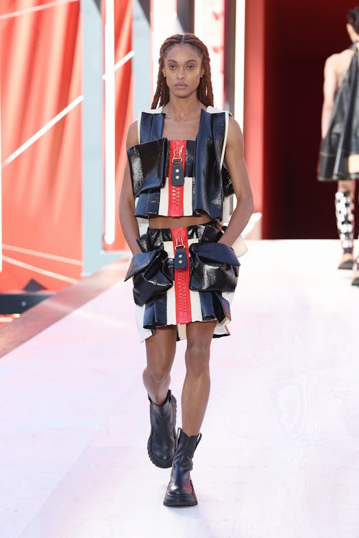 A model in a matching top and skirt with pockets and zippers at the Louis Vuitton Spring 2023 Paris ...