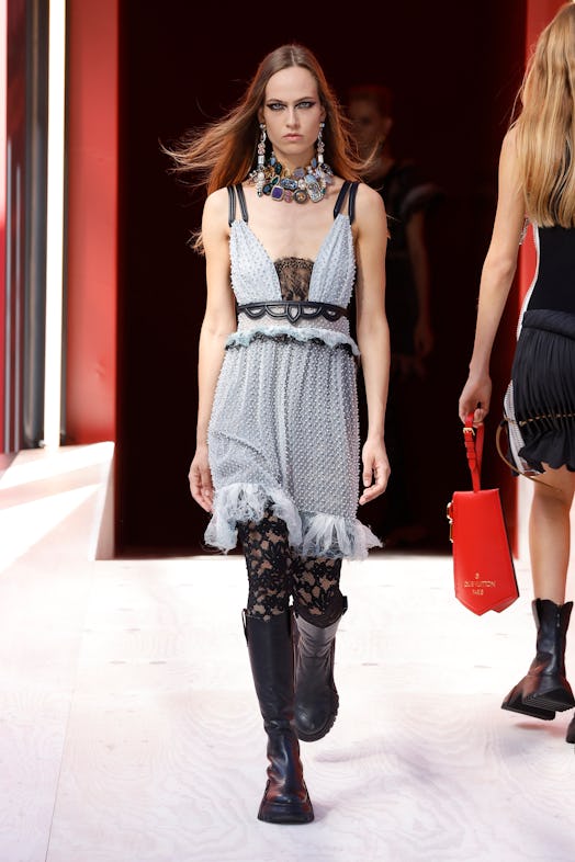 A model in a grey dress and black lace tights at the Louis Vuitton Spring 2023 Paris Fashion Week