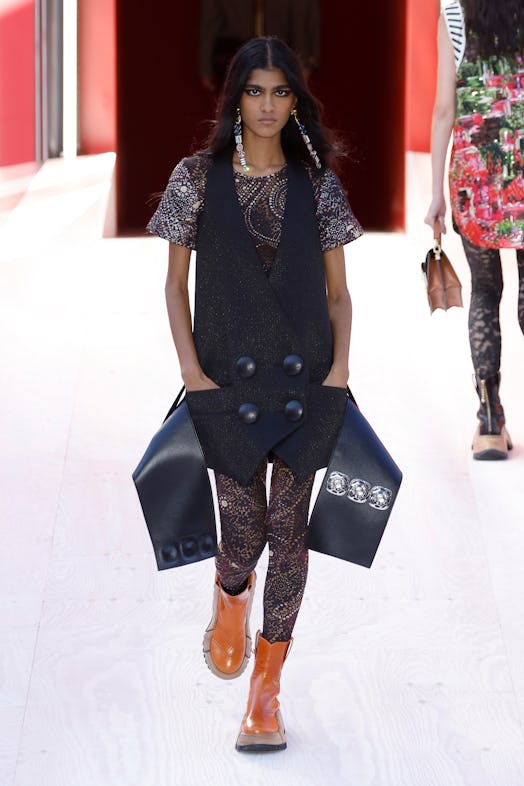 A model in a patterned brown top and oversized waistcoat at the Louis Vuitton Spring 2023 Paris Fash...