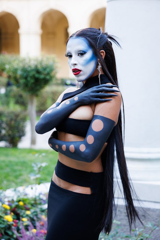 Doja Cat with her face painted white and blue at Paris Fashion Week 