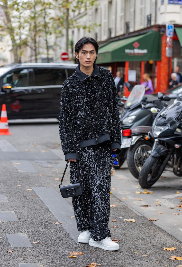 A guest wears sequined track suit in black outside Valentino Paris Fashion Week - Womenswear Spring/...
