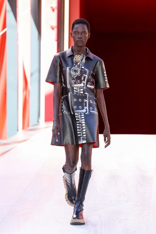 A model in a black leather dress with belt print at the Louis Vuitton Spring 2023 Paris Fashion Week