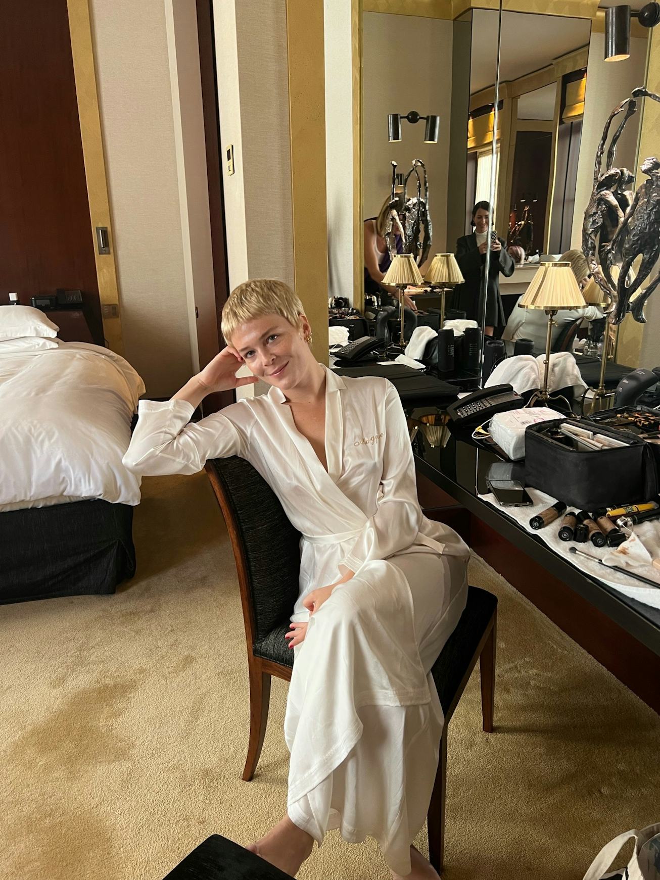 American singer Maggie Rogers with blonde hair, wearing a white dress, getting ready for Louis Vuitt...