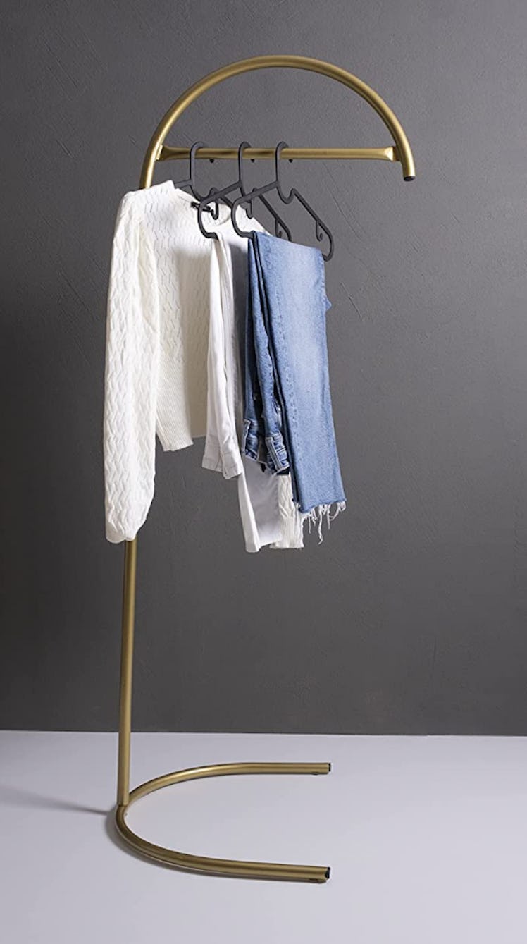 The gold half moon metal clothes rack is an Emma Chamberlain home decor dupe.