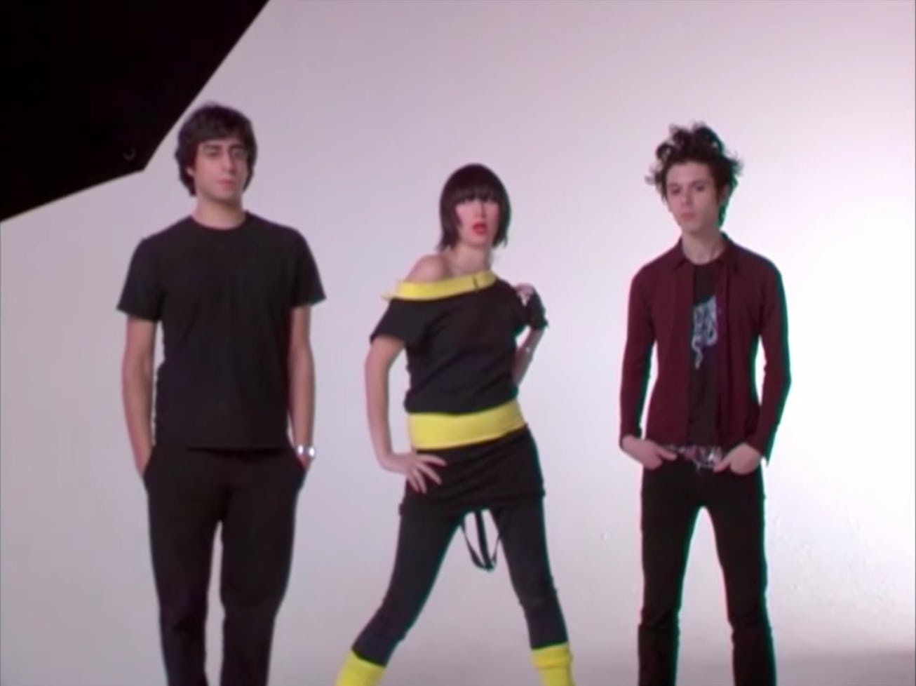 Three people stand in front of a white screen for the documentary "Meet me in the Bathroom." 