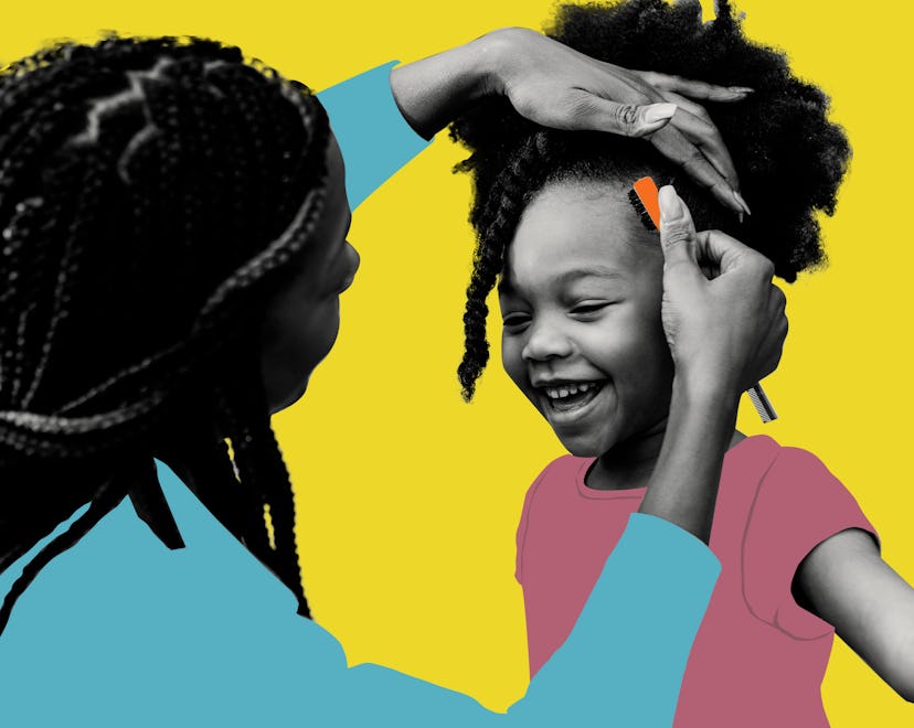 A black mother styling her daughter's hair while she is smiling