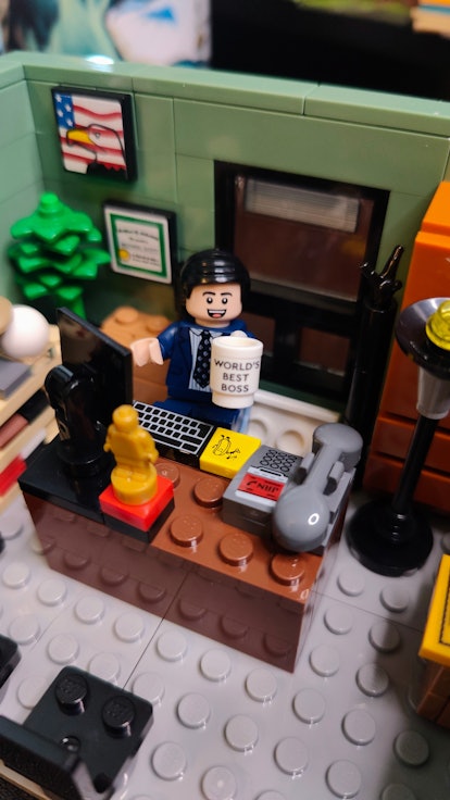 Michael Scott Lego minifigure at a Lego office desk, holding a mug that says "world's best boss".